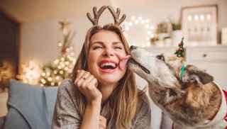 Woman with Christmas reindeer antlers with dog