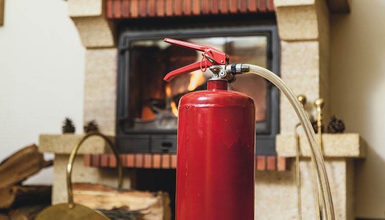 A fire extinguisher in front of a home fire.