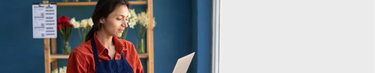 businesswoman flower store owner standing with laptop