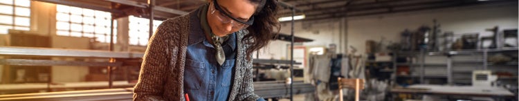 Focused female architect in her workshop working on project