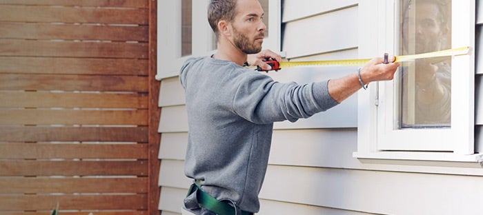 Handyman measuring windows