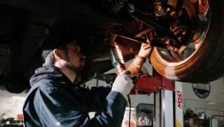Mechanic repairing raised car