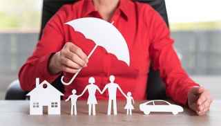 paper cut-out family with protective umbrella over them