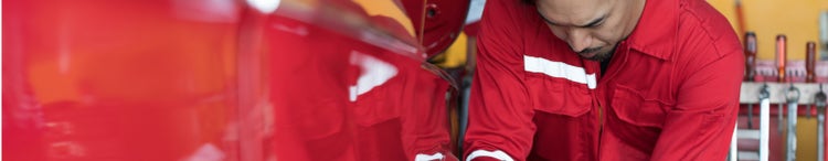 male mechanic using wrench to change tyre