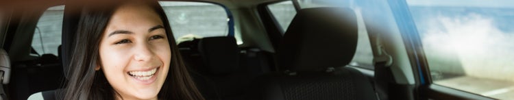 young smiling woman driving car