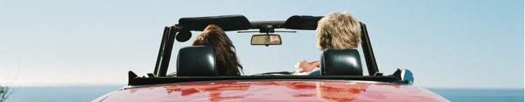Woman and man sitting in a convertible.