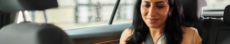 woman sitting in car on her phone