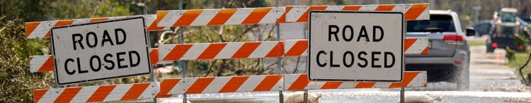 road closed with warning signs blocking drivers