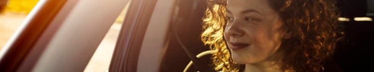 woman in car smiling out window