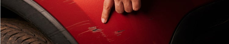 Man pointing to car scratch