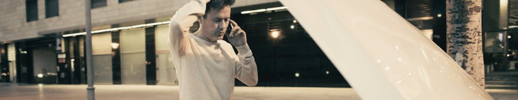 man on smartphone in front of car with open bonnet