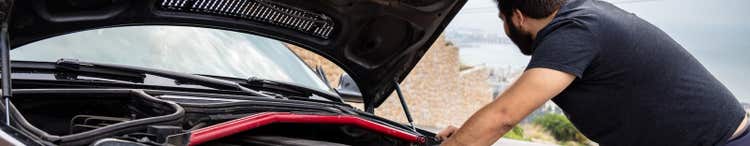 man looking in car engine