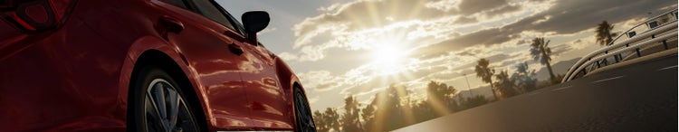 car driving on open road approaching trees