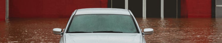 car in flooded car park-in front of red building