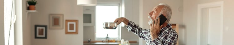 man holding pot catching water from leaking roof