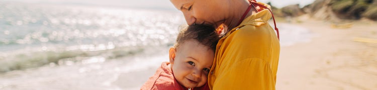 mother hugging son on beach
