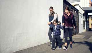 Happy young couple walking with little girl