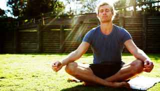 Man meditating in sunlight