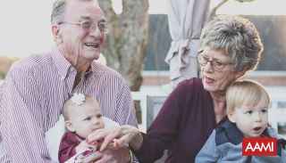 Elderly couple holding two babies