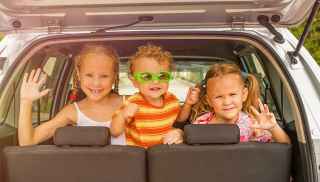 Three children in the back seat of a car