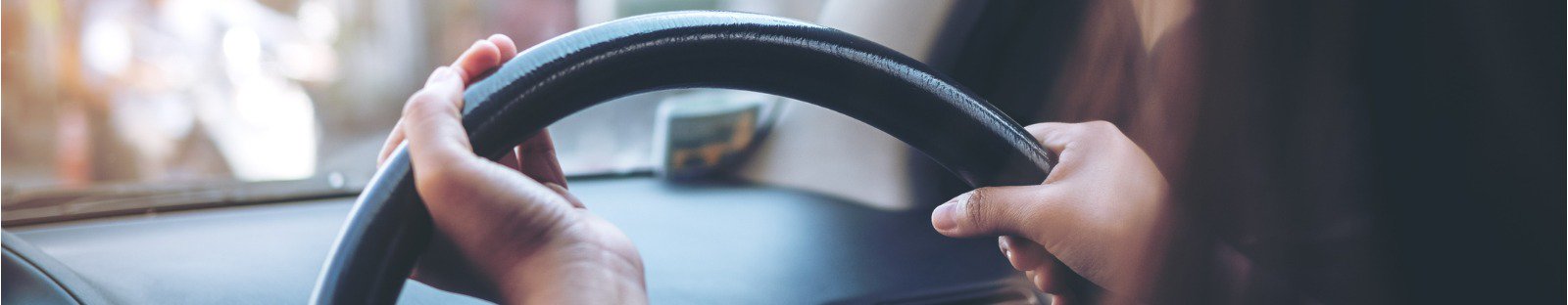 Close up of hands holding a car steering wheel