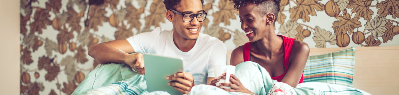 Couple at home using an ipad in bed 