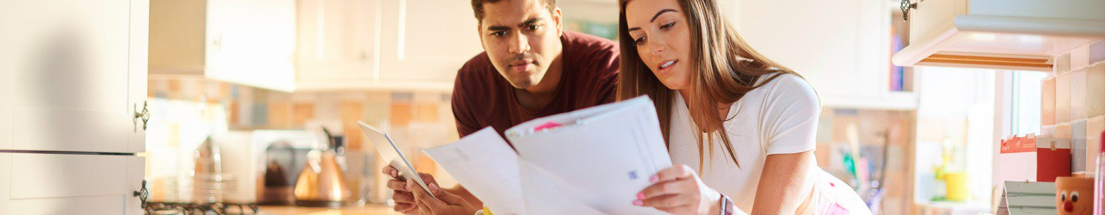 Couple inspecting document in their kitchen