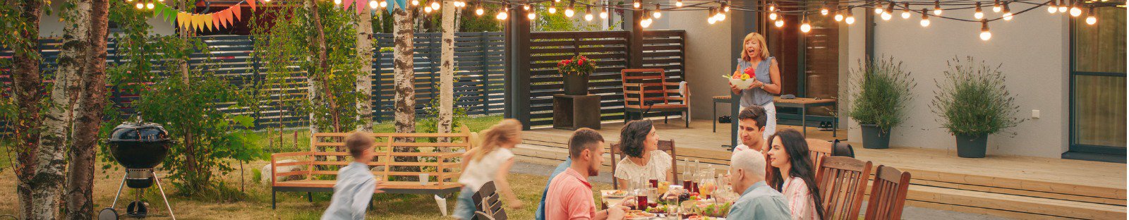 Family sitting around table in backyard