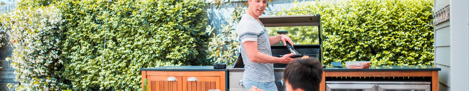 Man at outdoor barbecue offering food to children