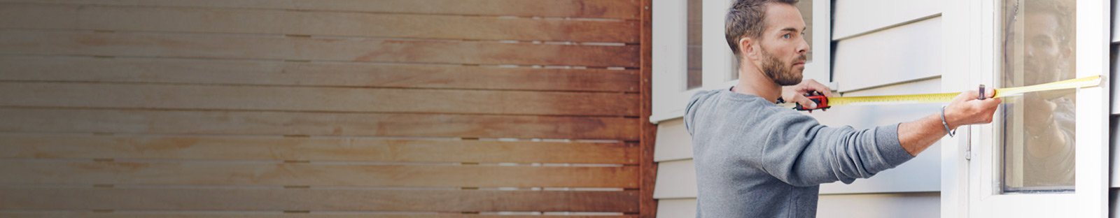 Tradesman measuring the outside of a window frame