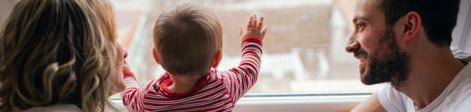 Parents with baby looking out window