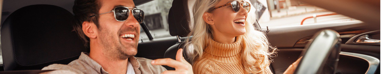 Smiling man and woman driving