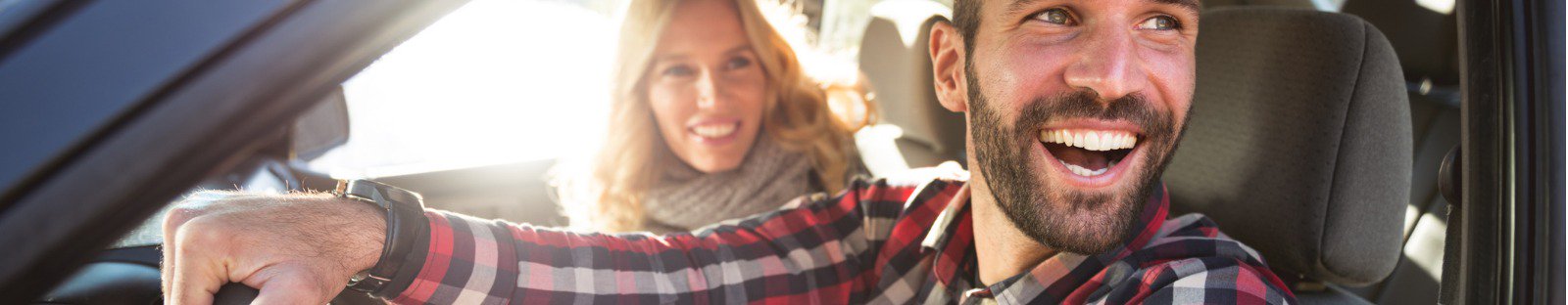 Smiling man and woman in car