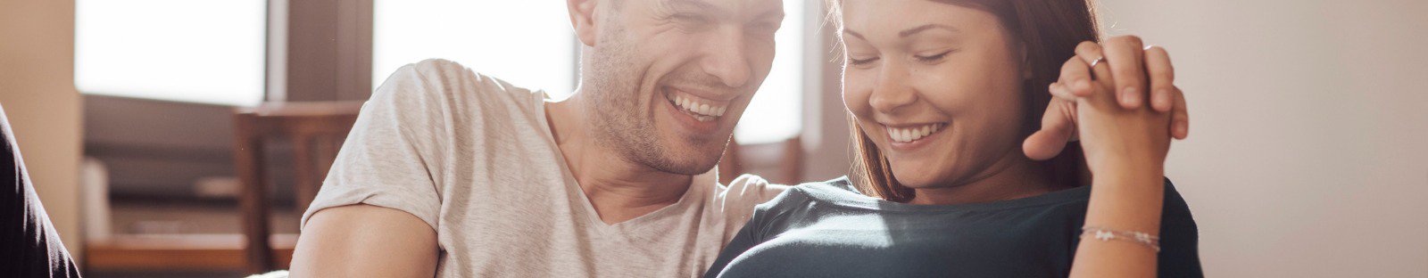 Smiling man and woman on couch