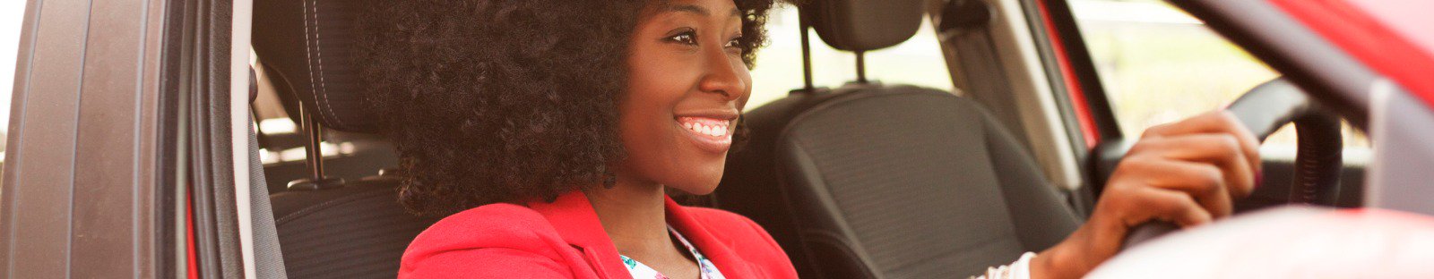 woman-smiling-driving-red-car