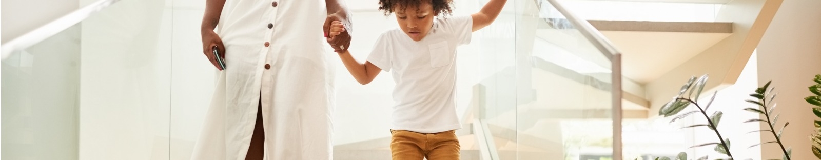 Woman holding toddler's hand as they walk down steps