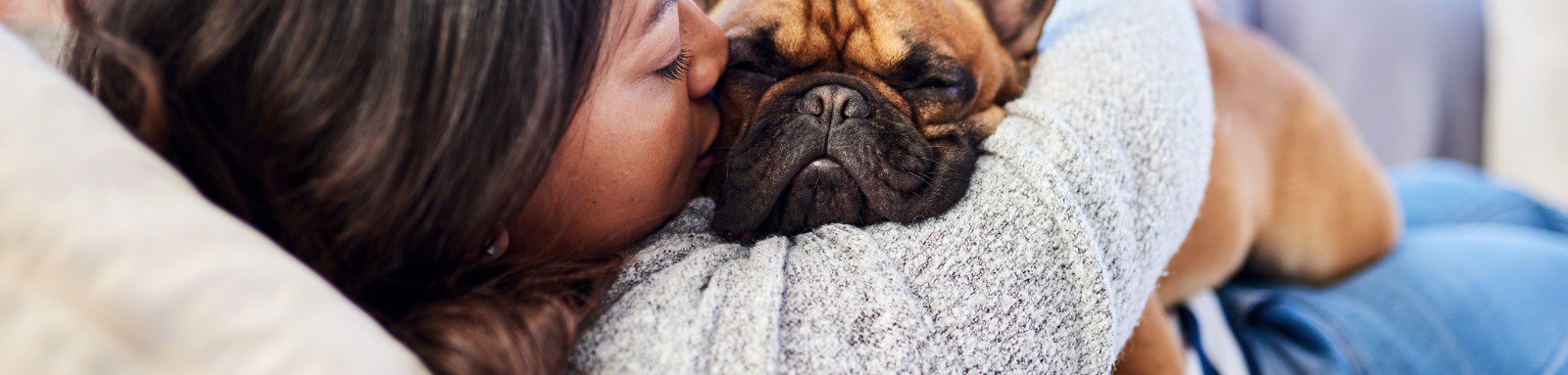 Woman on couch holding dog