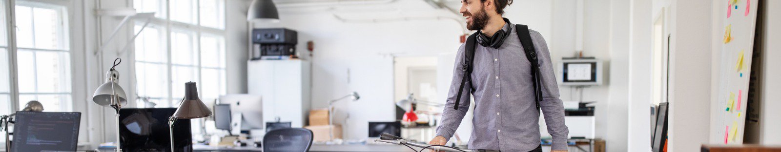 man walking bike through office