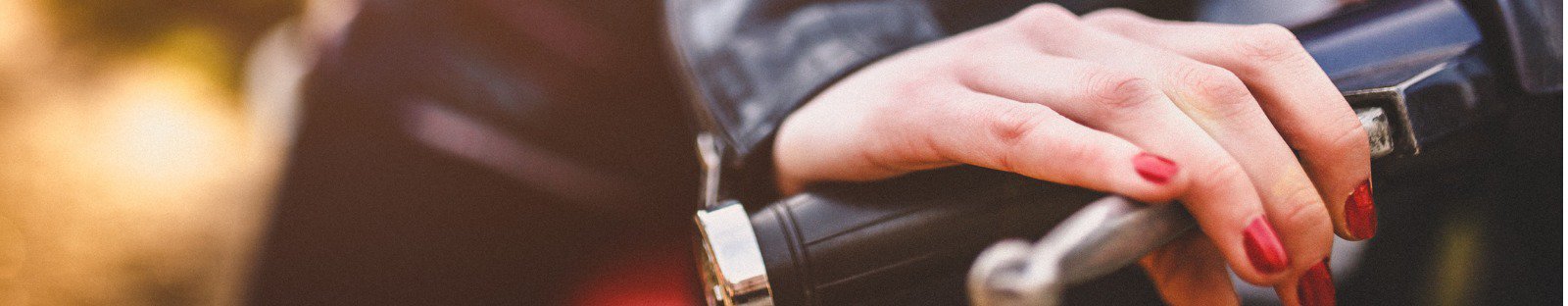 womans hand holding motorbike handlebar