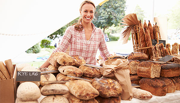 /content/dam/suncorp/insurance/aami/images/business/business-articles/woman-standing-behind-loaves-of-bread-600x342.jpg