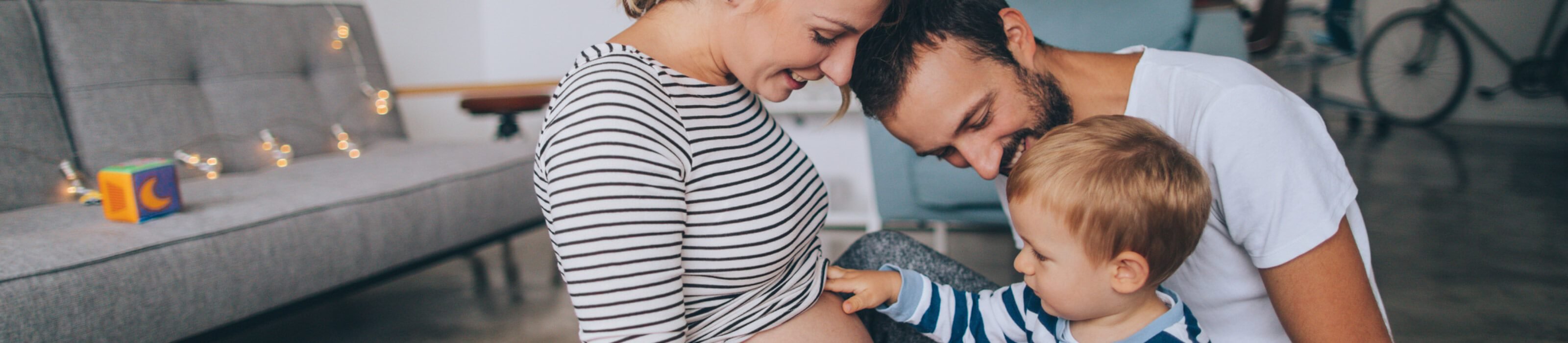 Young expecting family having a nice moment with their toddler