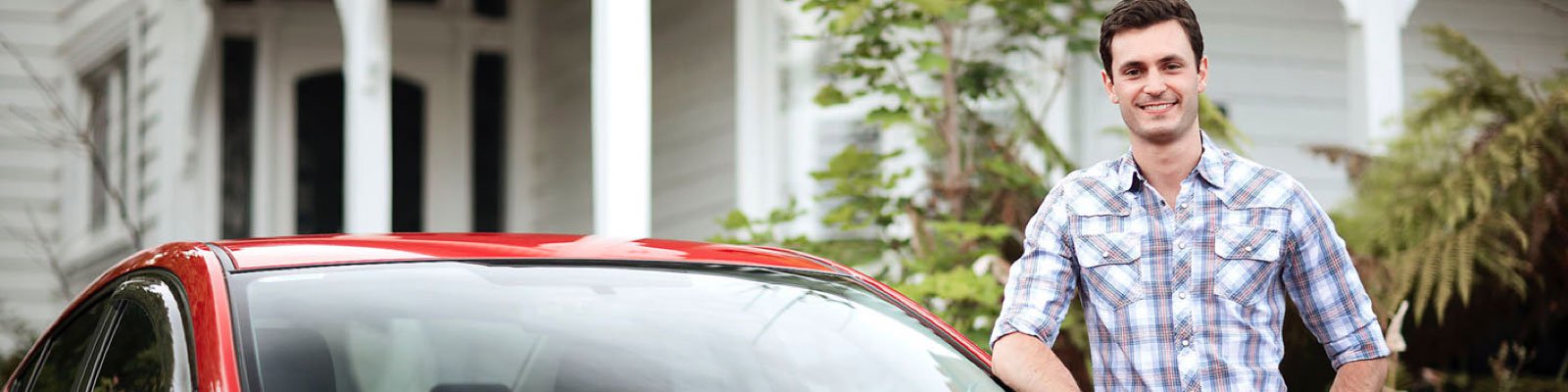 man standing next to red car