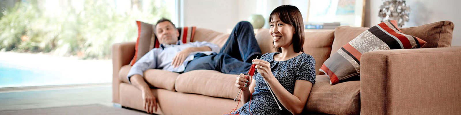 woman knitting and man lying down on couch