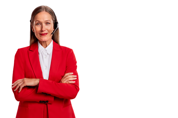 A professional woman dressed in a red blazer over a white shirt and wearing a headset is looking at the camera with her arms crossed