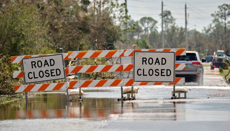 Road closed due to flooding, signified with warning signs