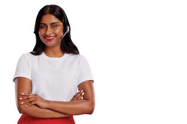 A professional woman dressed in a white t-shirt and wearing a headset is looking at the camera with her arms crossed and smiling