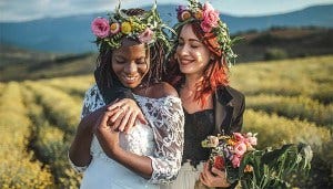 Smiling couple looking at wedding rings in a field
