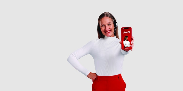 Professional woman holding out smartphone showing AAMI App screen