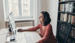 Woman working on computer at desk in home office