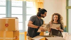 Couple looking at papers while surrounded by moving boxes